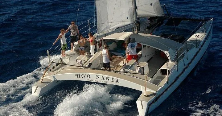 Catamaran HO'O NANEA sailing on a blue ocean with passengers on the deck.